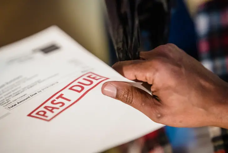 Hand holds an overdue mortgage notice